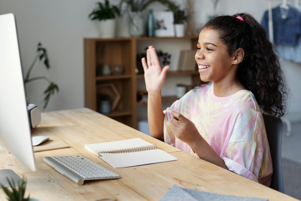 Young student engaging in an online GCSE English tutoring session, smiling and learning